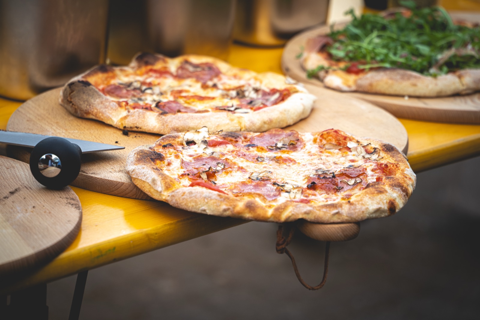 Frisch gebackene Pizzen auf Holzbrettern beim Pizza-Catering